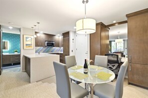 Une cuisine moderne dotée d’un îlot central, d’une table à manger avec des chaises et d’un lustre.
