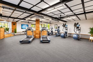 A gym with treadmills, elliptical machines, and a stationary bike.