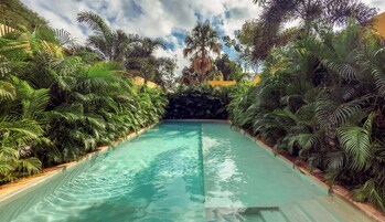 Una piscina al aire libre, sillones reclinables de piscina