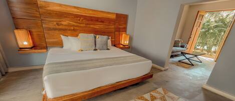 Un dormitorio con cabecera de madera, una cama grande, dos lámparas de noche y vistas al exterior.
