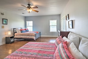 A bedroom with two beds, a ceiling fan, and two windows. - ‘Gingerland Ranch’ in Del Valle: Game Room & Porch (Del Valle)