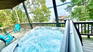 A hot tub on a wooden deck with a view of a lake and trees. - Massive Lakehouse - Infinity Pool, Hot Tubs, Dock, Firepit (Gainesville)
