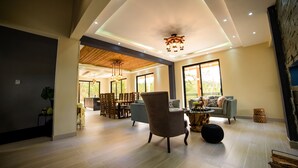 Ein geräumiger Wohnbereich im modernen Design, mit einer großen Couch, einem Couchtisch und einem Essbereich mit Holzmöbeln.
