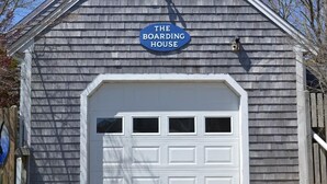 Un bâtiment sur lequel on peut lire l’inscription « The Boarding House » au-dessus d’une porte de garage blanche.