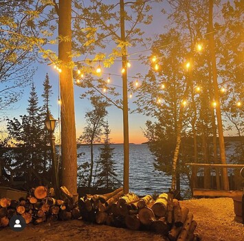 Upper firepit with globe lights and view of georgian bay. 