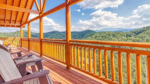 Una terraza de madera con barandilla, con vistas a un paisaje montañoso.