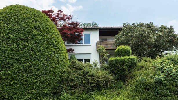 A modern two-story house surrounded by lush greenery and a well-maintained garden. - Apartment "Säntisblick" with Beautiful View of Lake Constance and the Alps (Daisendorf)