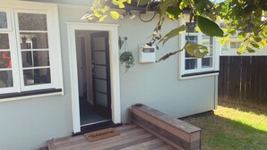 A house with a front door, a welcome mat, a small porch, and a wooden bench.