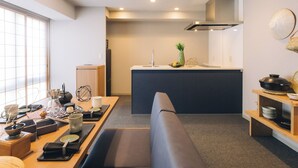 Una cocina moderna con una isla central, un comedor con banco y vistas de la ciudad a través de amplios ventanales.