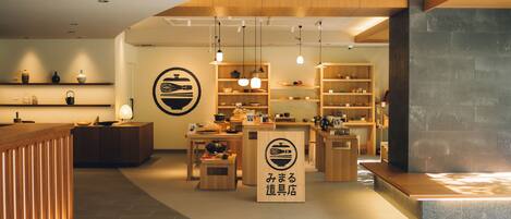 Un interior moderno con muebles de madera, estantes con utensilios de cocina y un letrero con caracteres japoneses.