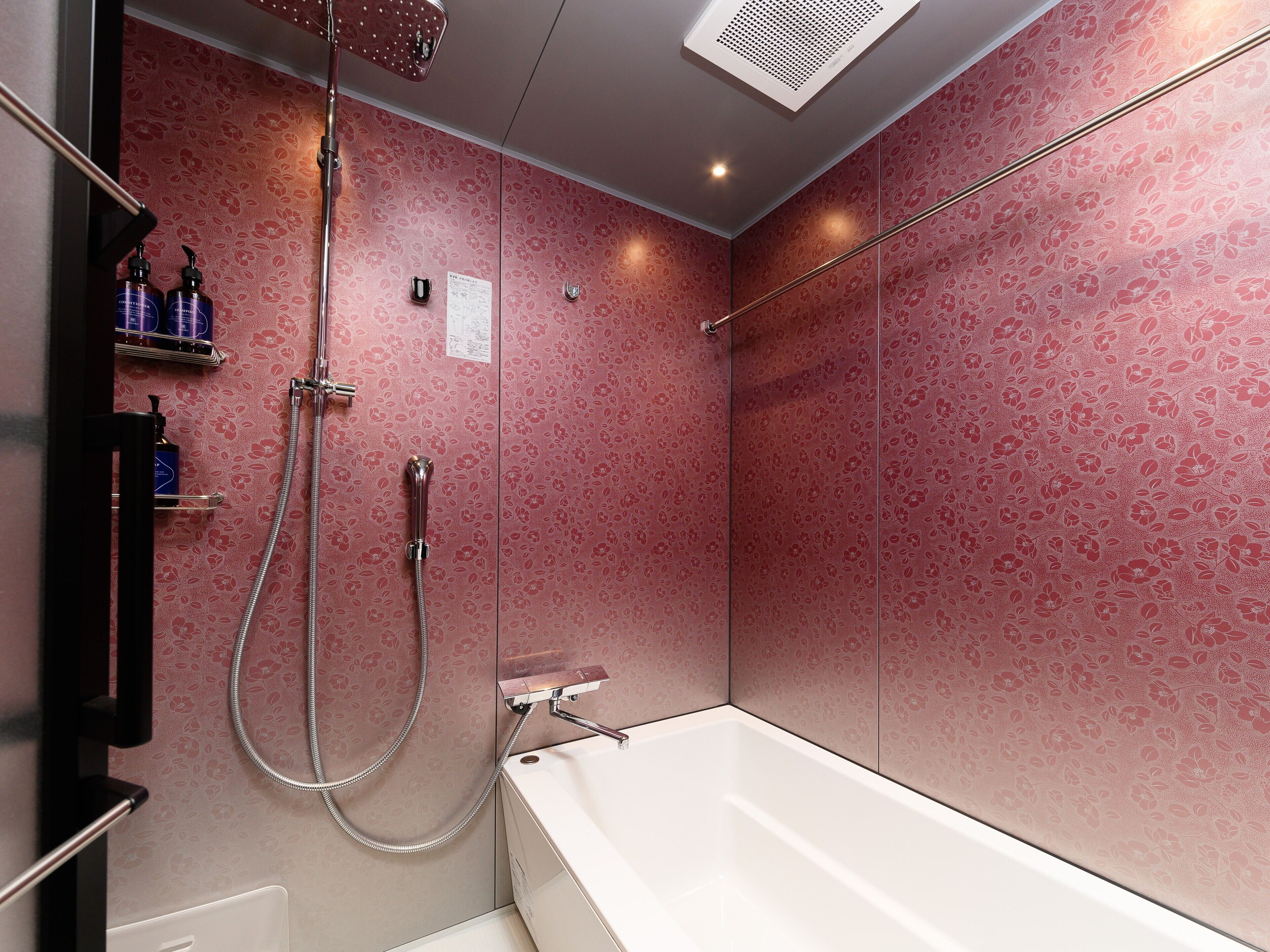 A modern bathroom with a shower, a bathtub, and a vanity with toiletries.