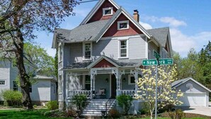 Ein zweistöckiges Haus mit Veranda, Garage und einem Straßenschild, das 'New York Ave' zeigt.