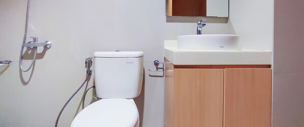 Une salle de bain avec des toilettes, un lavabo et une douche.