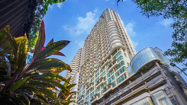 Un edificio alto y moderno con una fachada curva distintiva y varios balcones.