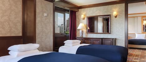 Una habitación de hotel con dos camas, un espejo grande, una ventana con cortinas y una lámpara en una mesita de noche.
