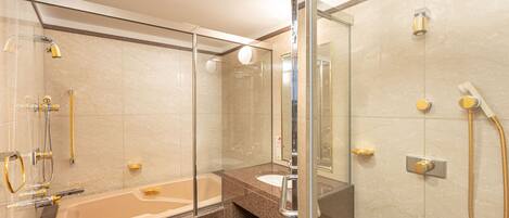 A modern bathroom with a glass-enclosed shower, a standalone bathtub, and a vanity with a sink.