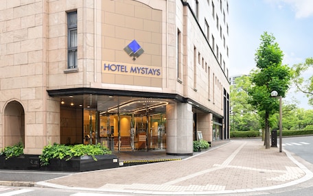 A hotel entrance with a sign reading "HOTEL MYSTAYS".