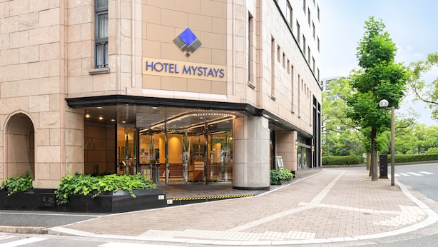 A hotel entrance with a sign reading "HOTEL MYSTAYS".