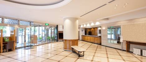 A spacious lobby with a checkered floor, a reception desk, and a seating area.