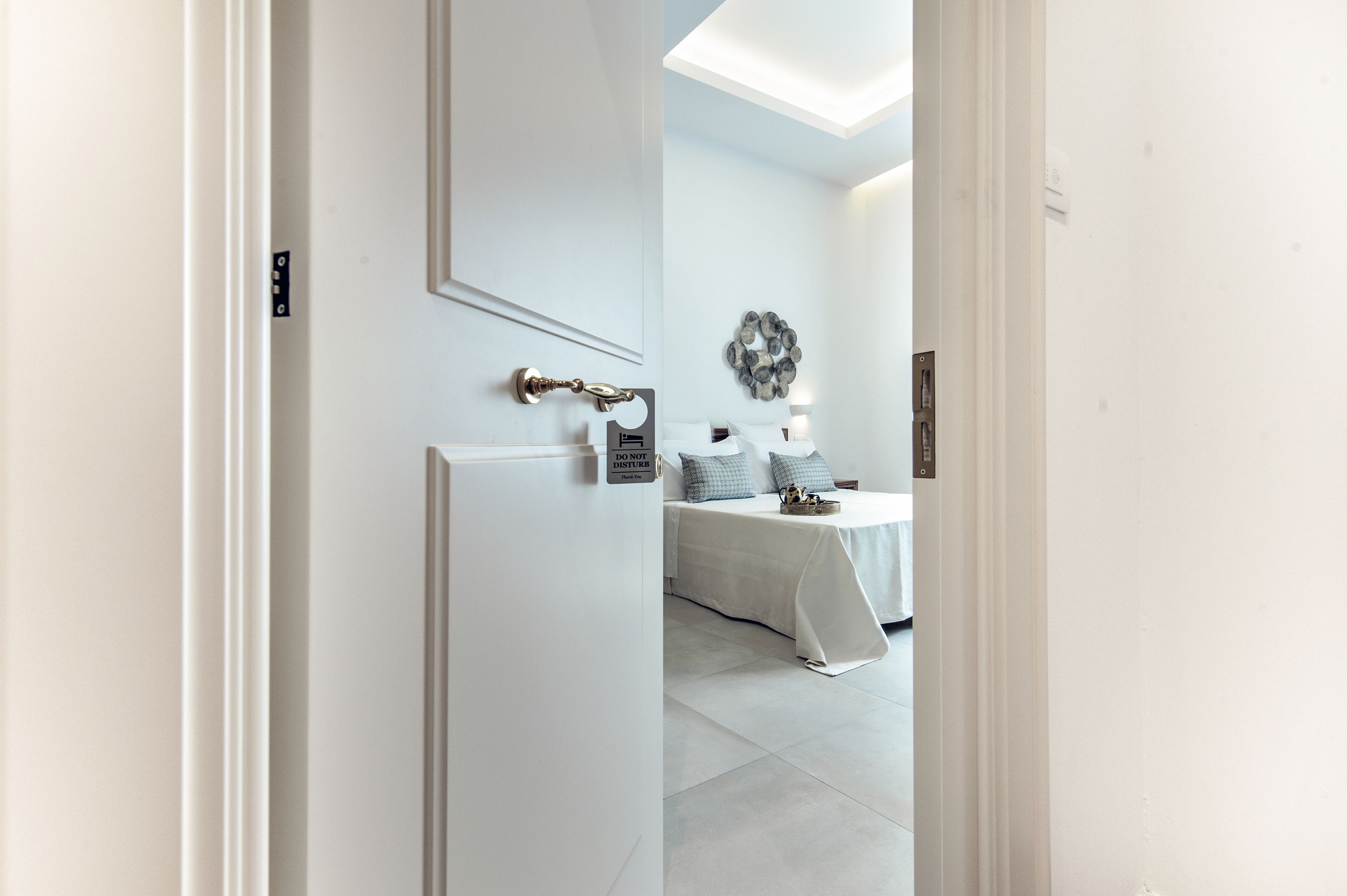 Una habitación de hotel con una cama, una mesita de noche, una lámpara de pared y un adorno en la pared.