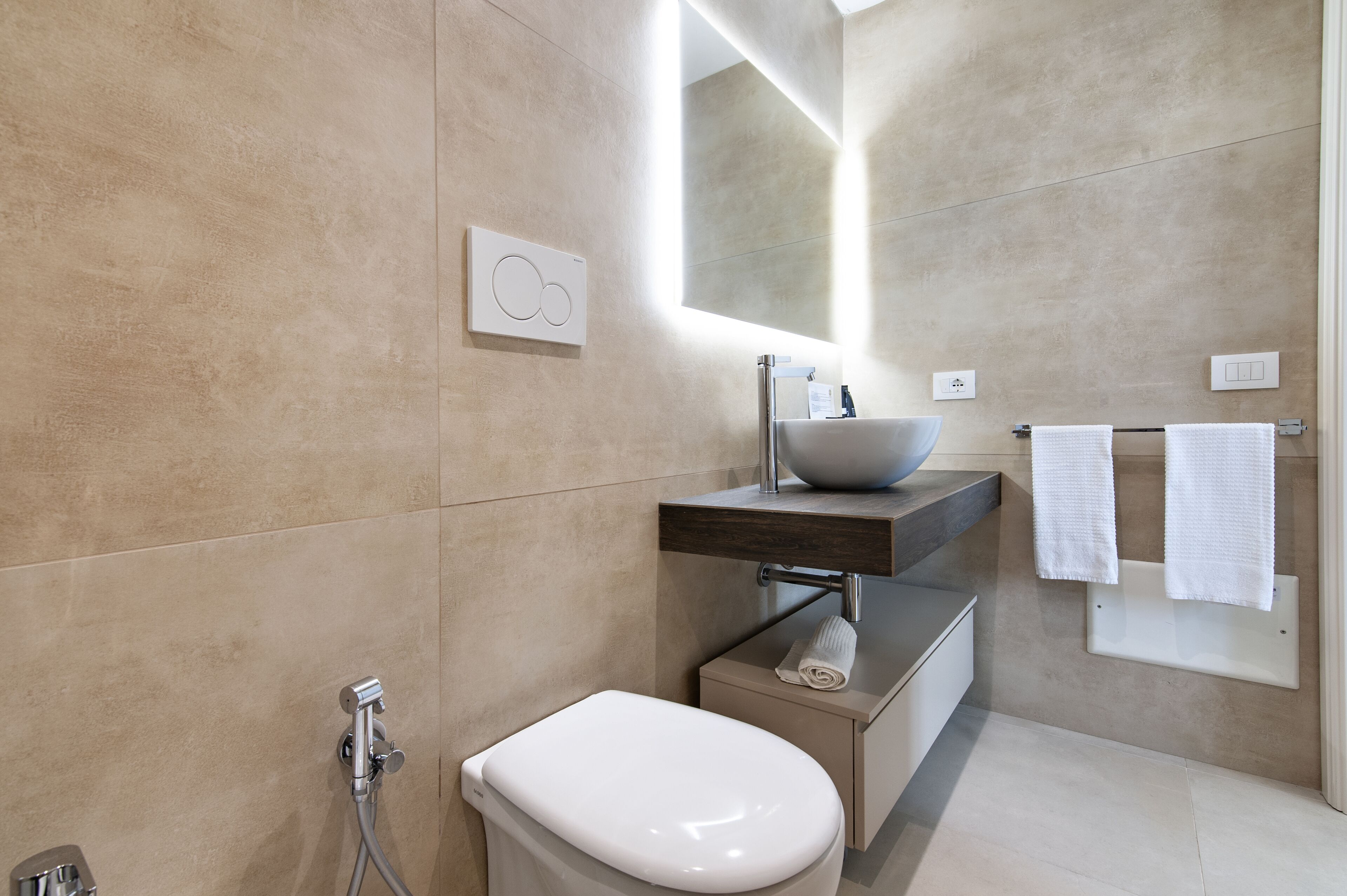 A modern bathroom with a toilet, sink, and towel rack.