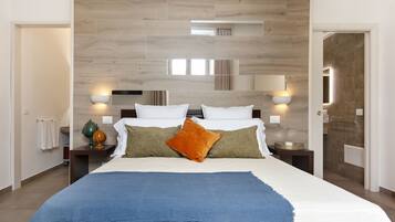 A modern bedroom with a large bed, two bedside tables, and a wooden headboard.