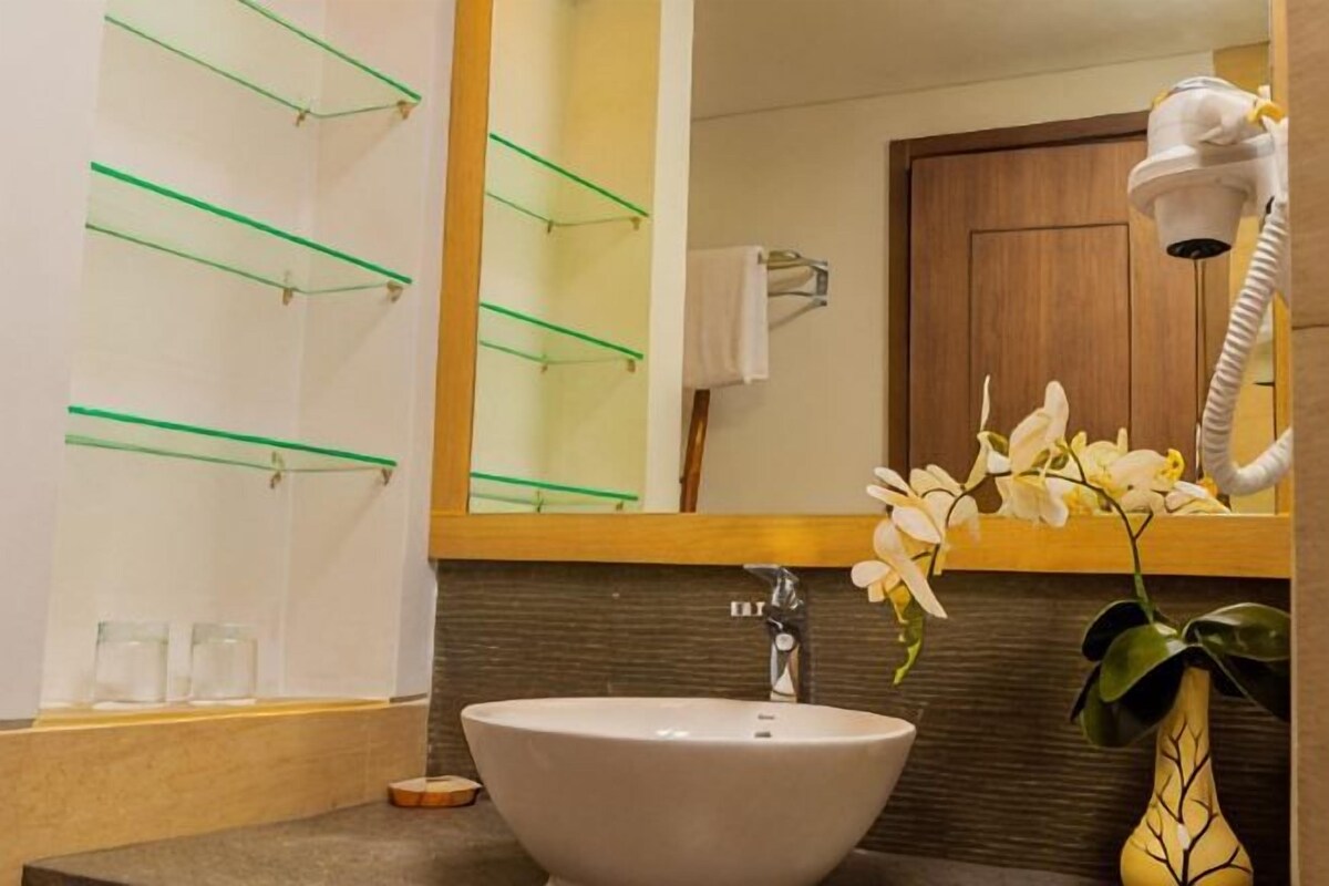 Un bagno con lavandino, specchio e asciugacapelli.