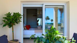 A balcony with a bed, a plant, and a chair. - Phaedrus Living: Seaview Luxury Flat Limnaria 151 (Paphos)