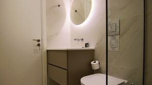 A modern bathroom with a toilet, sink, and mirror. - Phaedrus Living: Seaview Luxury Flat Limnaria 151 (Paphos)