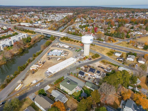 An aerial view of a town with a prominent water tower, a highway, and a river. - Rehoboth Beach Pet Friendly Condo Linens Included Fire Pit Parking (Rehoboth Beach)