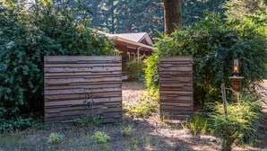 A wooden gate leading to a building surrounded by dense foliage. - Spectacular Golf Group Vacation Rental at Bandon Dunes Golf Resort (Bandon)