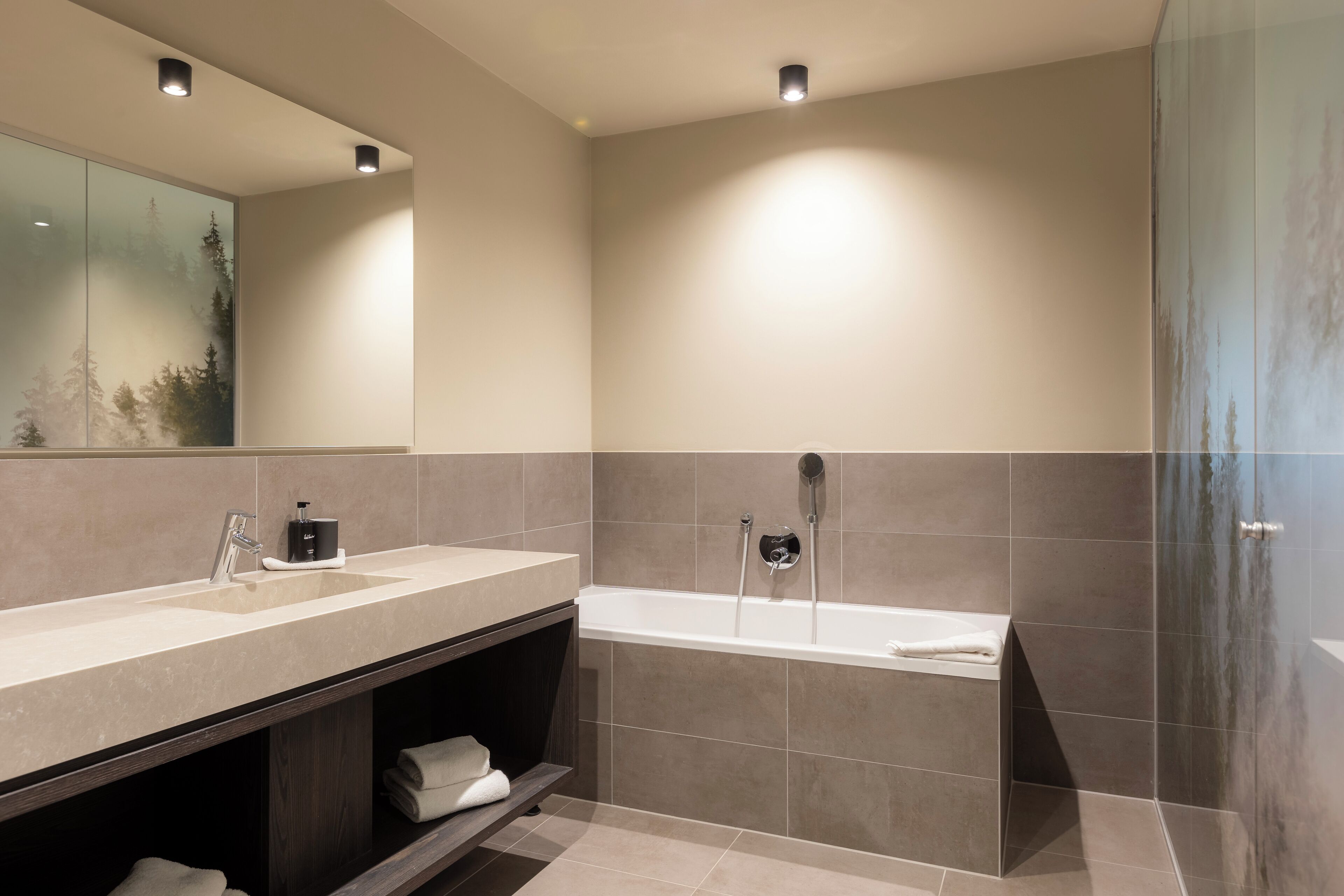 Un bagno moderno con uno specchio grande, due lavandini, una vasca da bagno e una doccia.