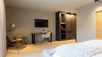 Un dormitorio moderno con cama, escritorio, silla y armario.