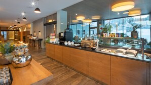 Un restaurant moderne doté d’un comptoir en bois, de vitrines et d’un éclairage suspendu.
