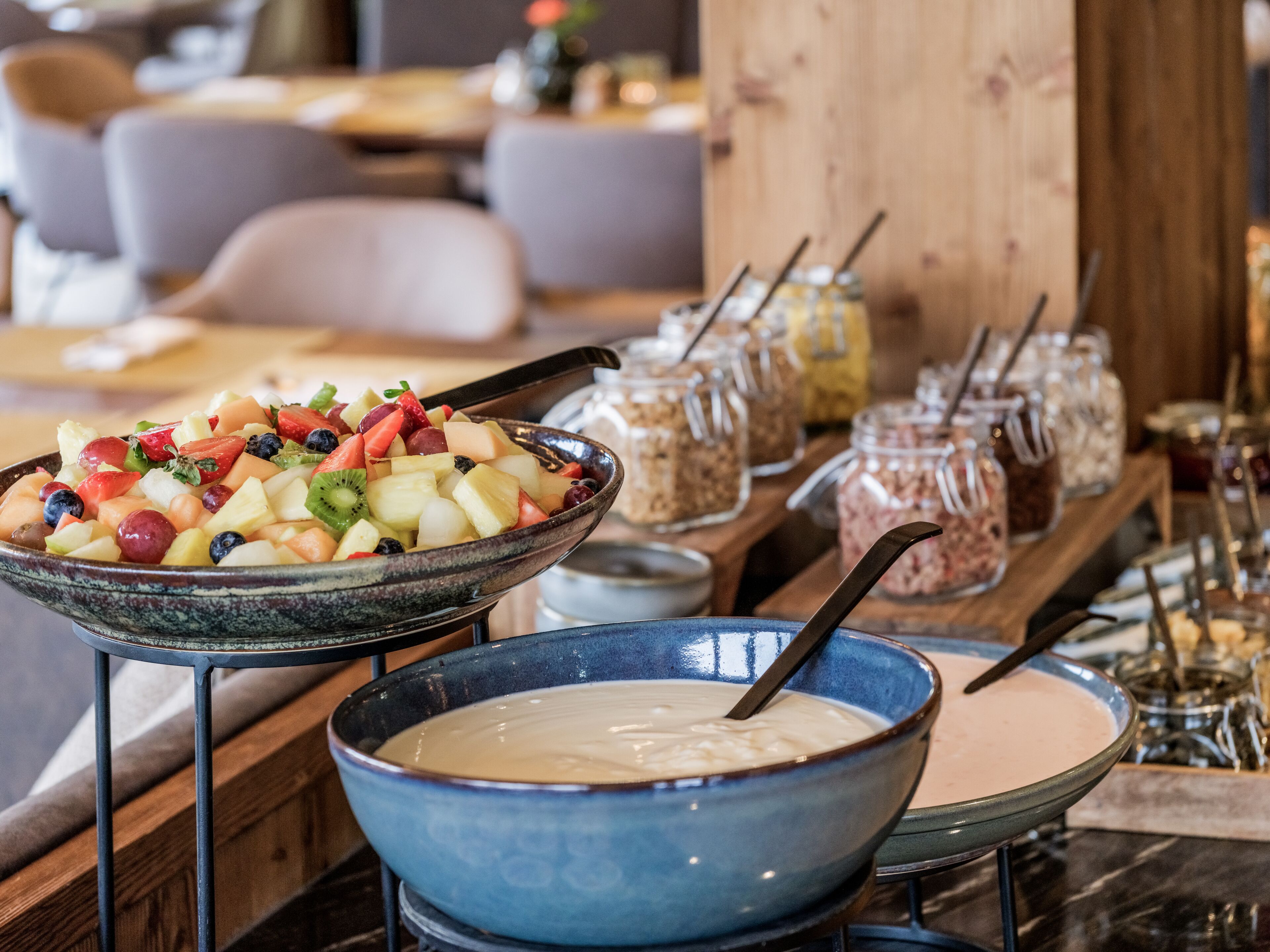 A buffet with a variety of fruits and a bowl of soup.