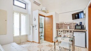 A compact living space with a kitchenette, a dining area, and a bathroom. - GuestHost - Bright apartment equipped with every comfort to accommodate up to 4 people and located in the center of Polignano, in an area equipped with all essential services, easily reachable on foot. The flat is 400 meters from the lively Piazza Vittor (Polignano a Mare)