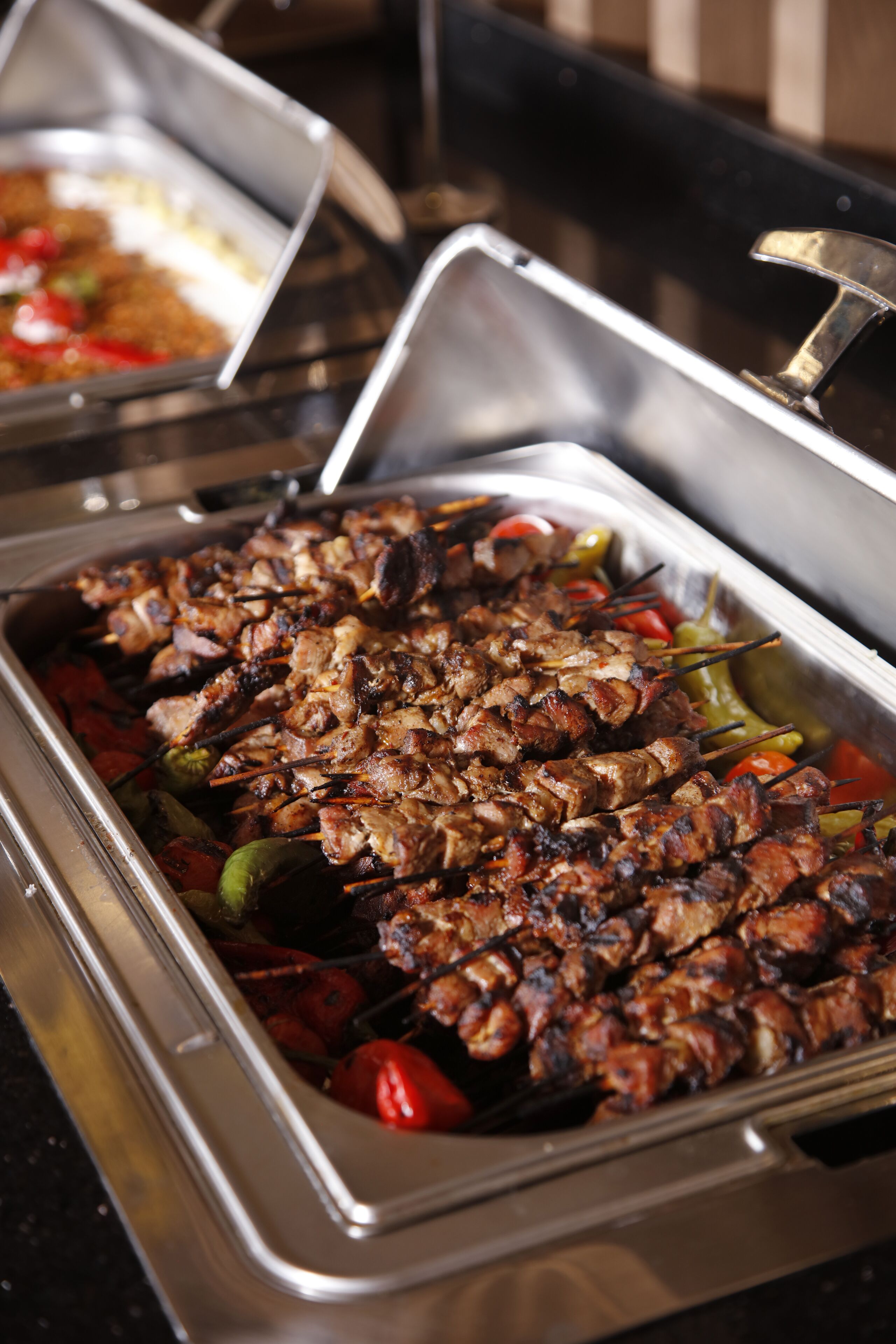 Buffet com carne e legumes espetados.