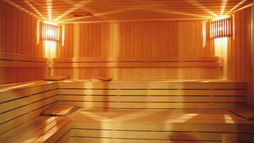 Una sauna con bancos de madera y paredes con listones, que incluye luces empotradas.