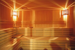 Una sauna con bancos de madera y paredes con listones, que incluye luces empotradas.
