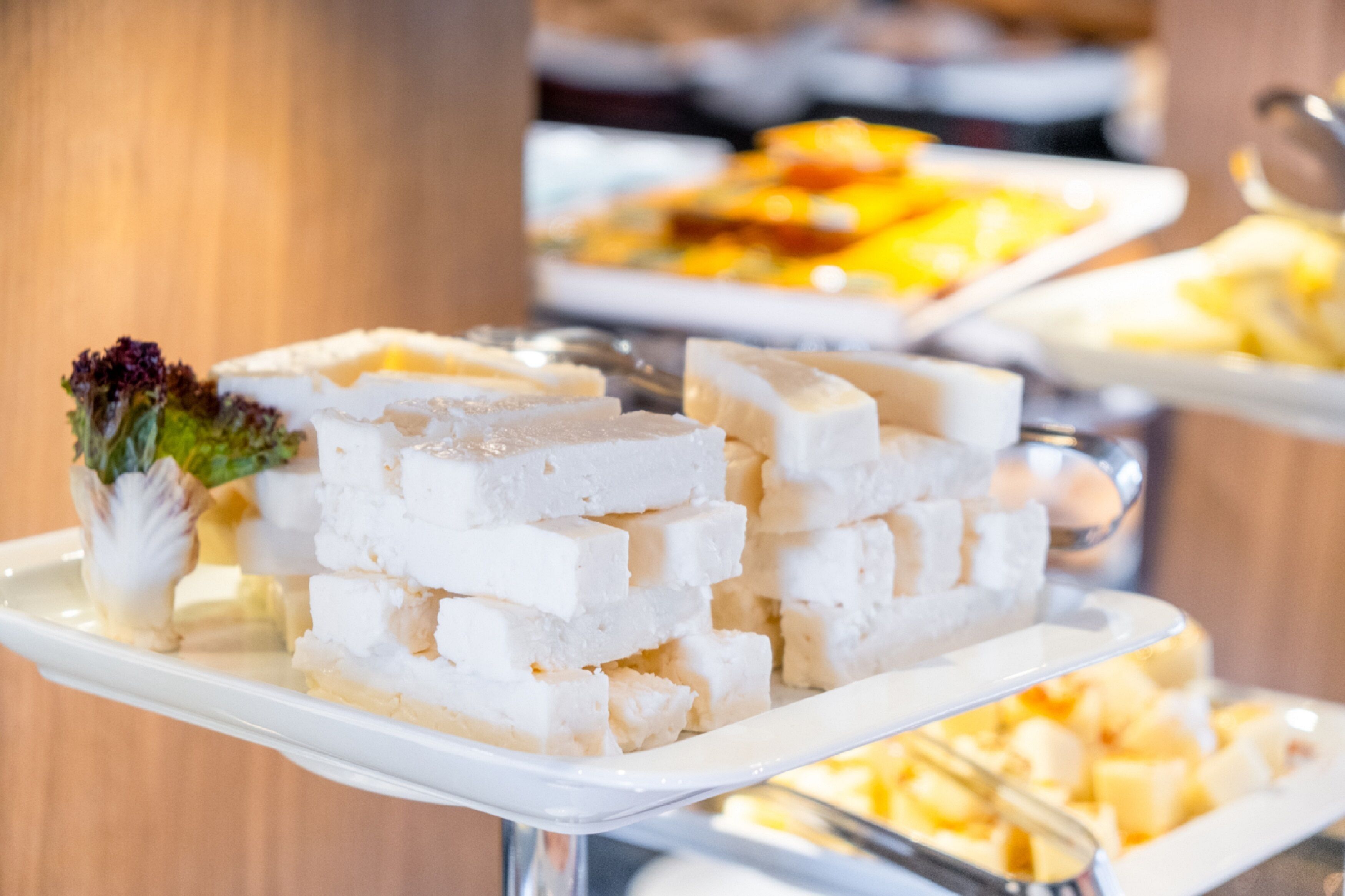 A buffet with various dishes, including a white cheese platter and other food items.