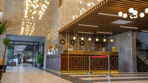 A modern hotel lobby with a reception desk, large chandeliers, and a staircase. - Allia Thermal Health & Spa Kazdagları (Edremit)
