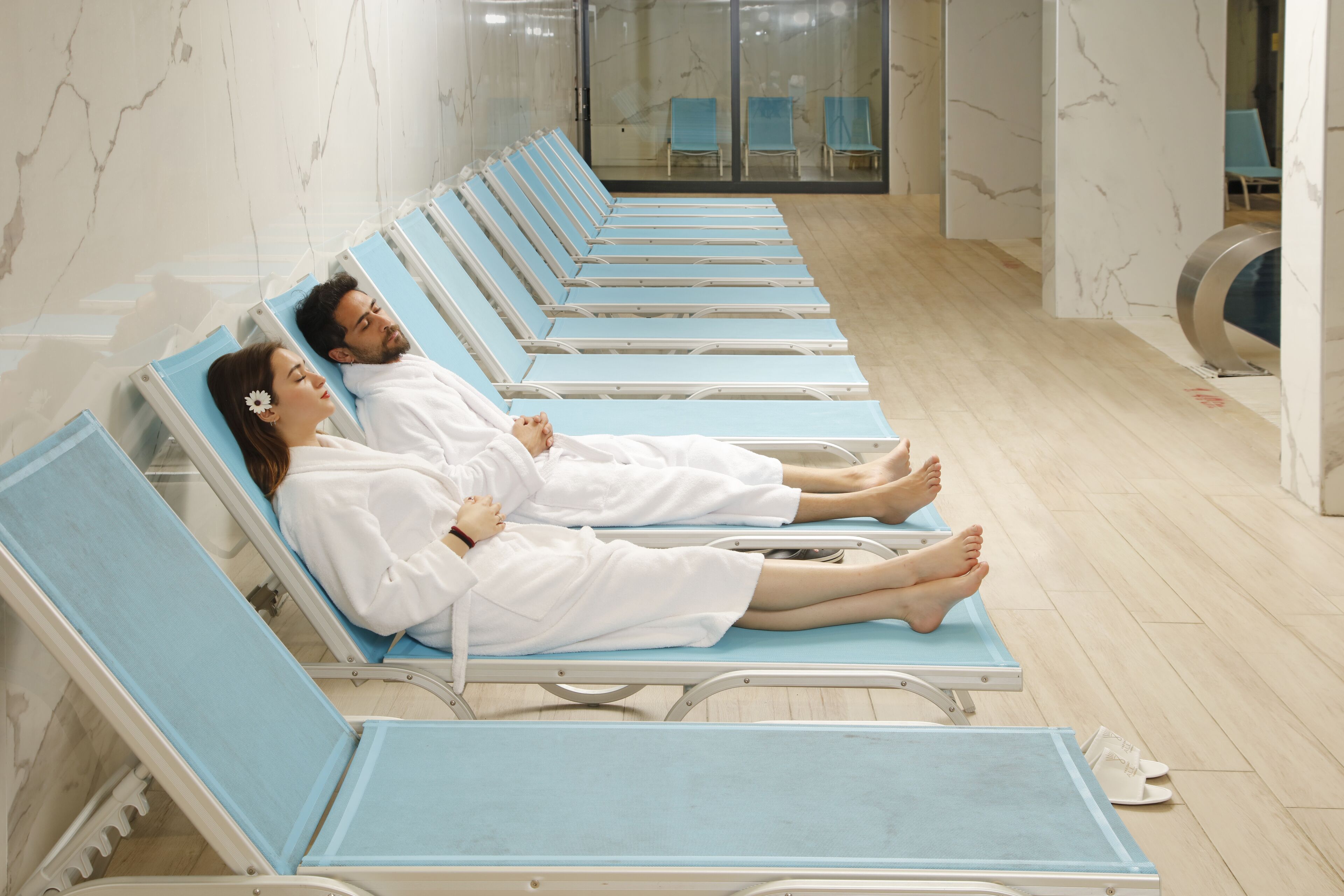 Una piscina cubierta, una piscina al aire libre de temporada, tumbonas