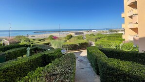 Een aangelegde tuin met een pad dat uitkomt op uitzicht over het strand.