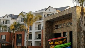 A building labeled "AQUATIC CEN" with kayaks displayed outside. - The Blyde 1317 (Pretoria)