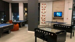 A modern recreational room with pool tables, foosball tables, and a television. - The Blyde 1317 (Pretoria)