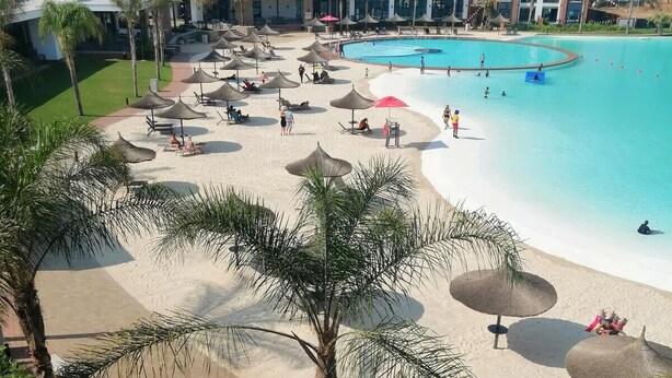 A beach resort with a large pool, sun loungers, and umbrellas. - The Blyde 1317 (Pretoria)