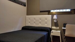 A hotel room with a bed, a small bedside table, a lamp, and a chair. - Hostal Sant Pau (Barcelona)