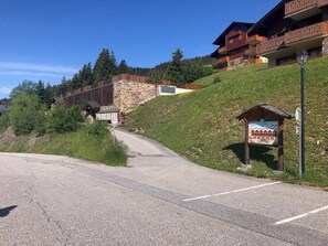 A mountain lodge with a stone facade, wooden balconies, and a signboard.