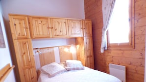 Un dormitorio con una cama, cabecera de madera y una ventana con cortinas.