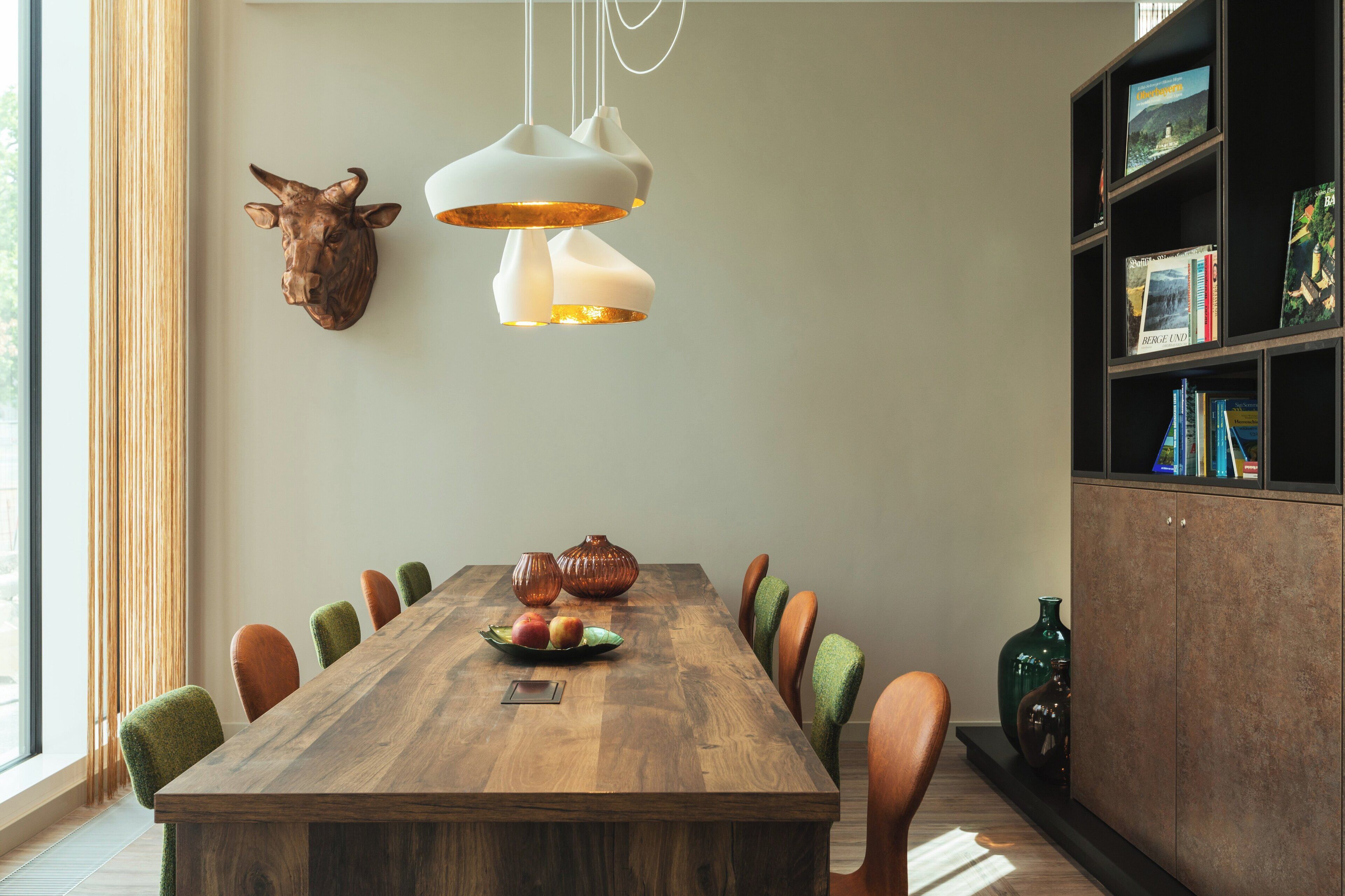 A dining area with a wooden table, chairs, and a bookshelf.